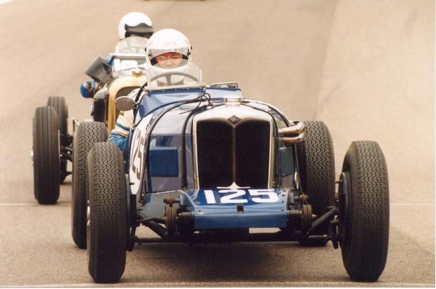 A blue Riley, number 125, racing wheel to wheel