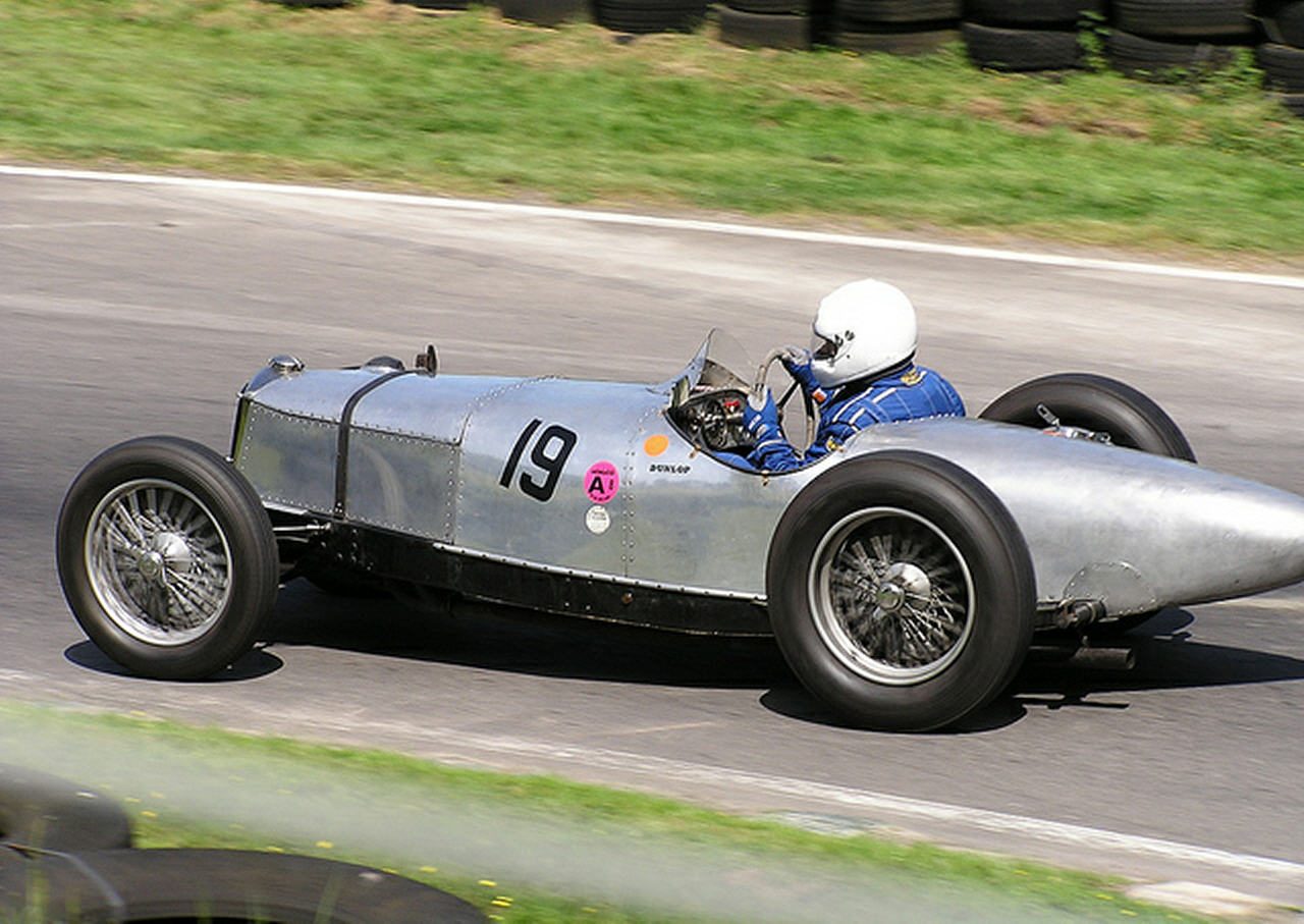 A silver streamlined Riley, number 19, racing
